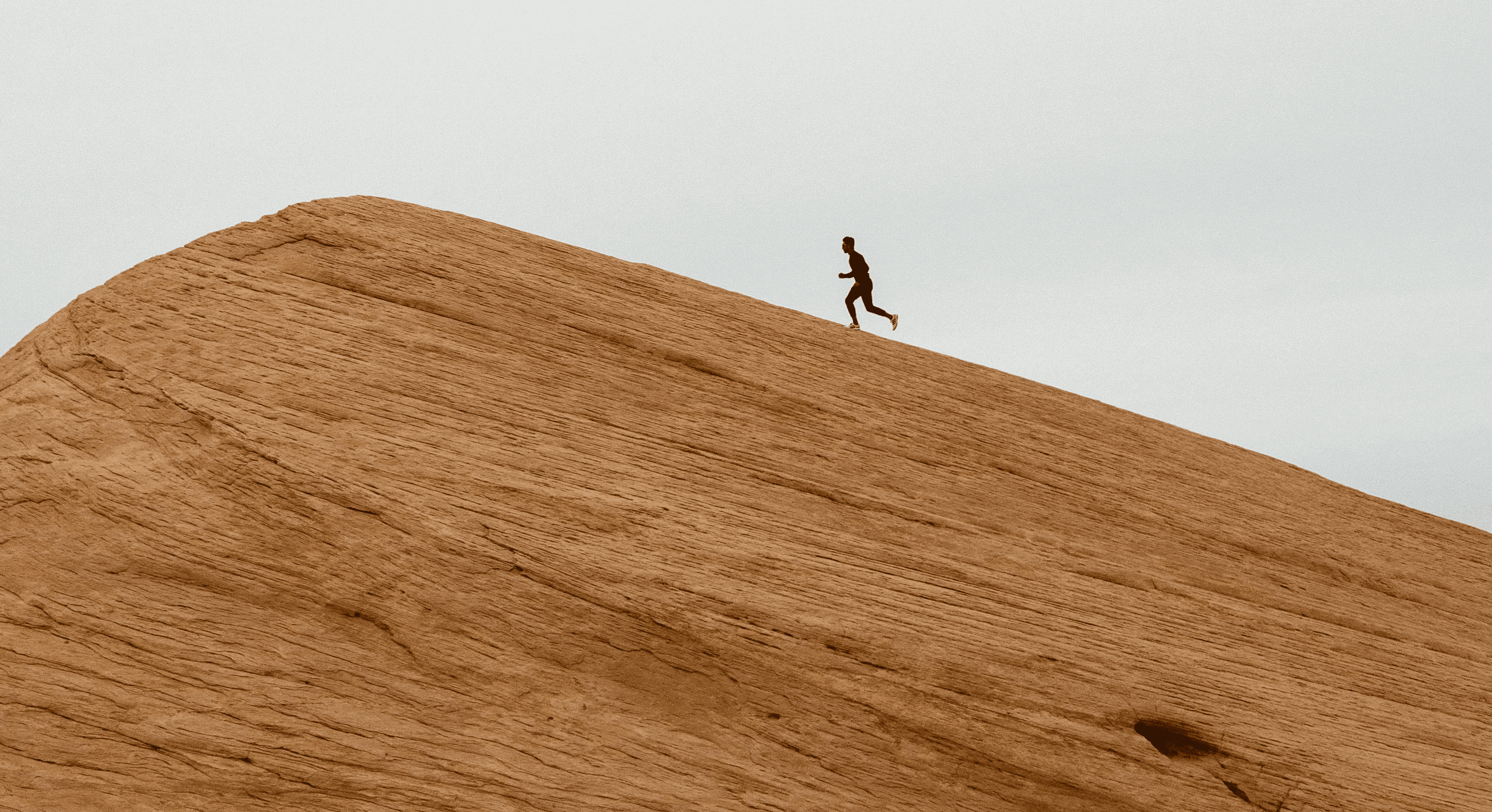 A runner climbing a steep wooden slope